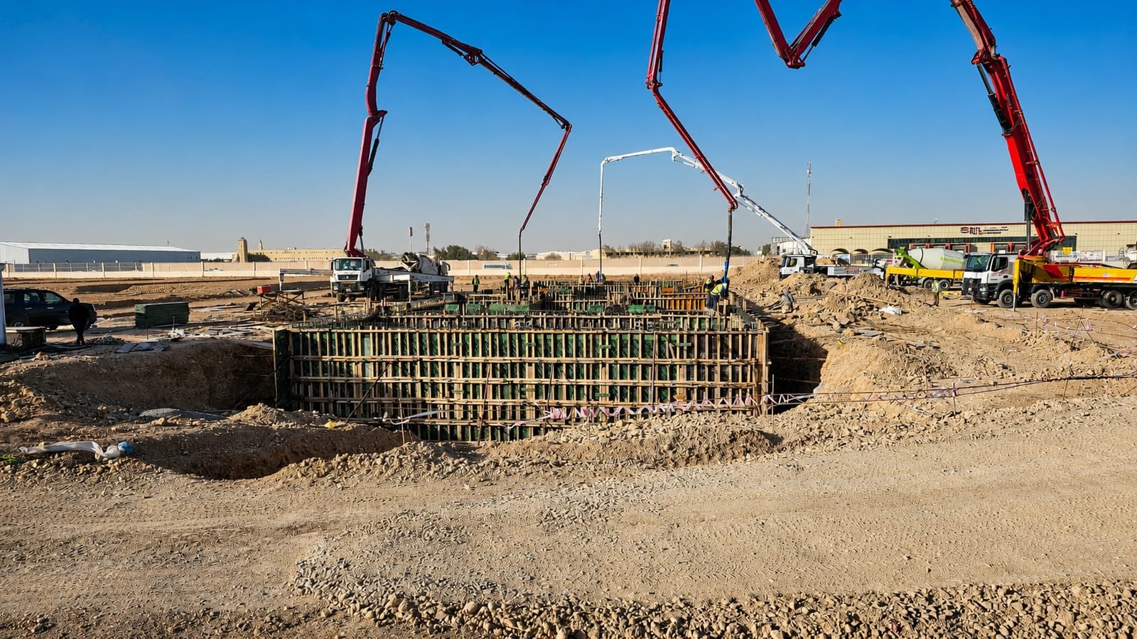 Concrete being poured into deep foundation formwork on a construction site